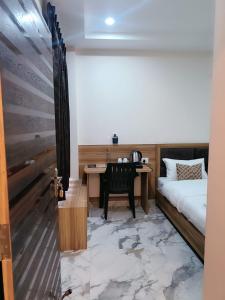 瓦拉纳西NANDI RETREAT HomeStay的客房设有一张床、一张书桌和电话