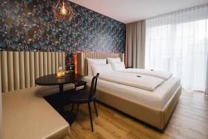 斯图加特Rioca Stuttgart Posto 6的酒店客房配有一张床铺和一张桌子。