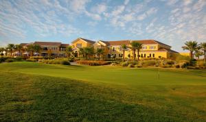 迪拜阿拉伯牧场高尔夫俱乐部酒店的一座带房屋和绿色植物的高尔夫球场