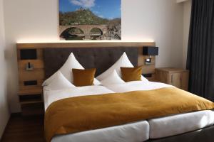 阿尔特纳尔Hotel-Restaurant Zur Traube的一间卧室配有一张带白色床单和黄色枕头的大床。