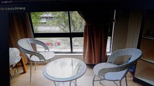 斗湖Homestay KNK的窗户前的三把椅子和一张桌子