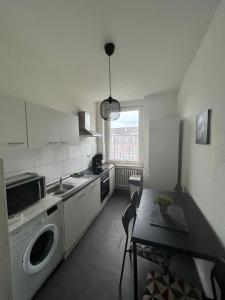 科隆Wohnung in Köln的厨房配有桌子和洗衣机。