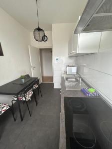 科隆Wohnung in Köln的一间小厨房,配有黑色台面和一张桌子