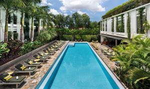 暹粒维鲁斯酒店的一张带躺椅的游泳池和一座建筑的图片