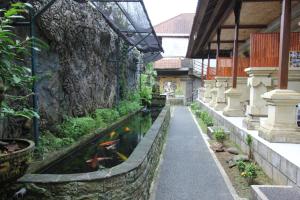 乌布Belvilla 93916 Budi House Near Ubud Palace的石头墙建筑中的锦 ⁇ 池