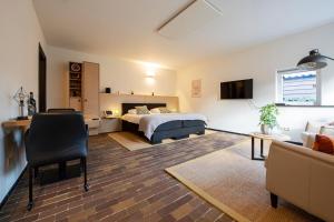 Sint-OedenrodeB&B aan het Dijksteegje的一间卧室配有一张床,客厅配有沙发