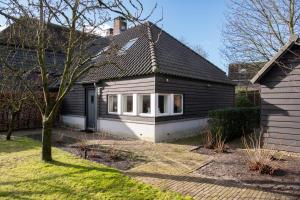 Sint-OedenrodeB&B aan het Dijksteegje的院子里有树的黑白房子