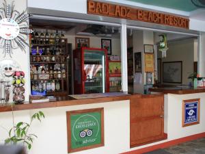 波尔多·格尼拉Badladz Staycation Condos的海滩度假胜地的酒吧,带有标志