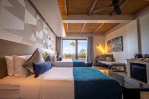 爱妮岛Maremegmeg Beach Club的一间卧室设有一张床和一间客厅。