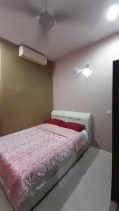 亚娄UMMUL MOTEL的一间卧室配有一张带粉色床单的床和风扇