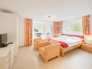 采尔马特粉雪公寓的一间卧室配有一张床、一张沙发和窗户。