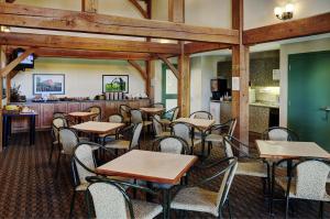 OkotoksLakeview Inns & Suites - Okotoks的一间带桌椅和柜台的餐厅
