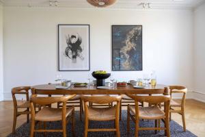 哥本哈根3 Bedroom Flat in Lovely Area的一间带木桌和椅子的用餐室