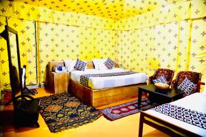 斋沙默尔Serendipity desert Camp in Thar Desert的一间黄色壁纸卧室
