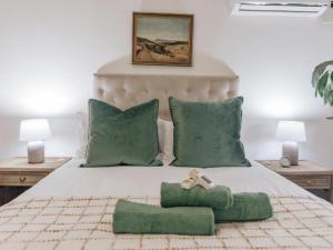 彼得马里茨堡Wylde Rose Cottage的一间卧室配有一张带绿色枕头的大床