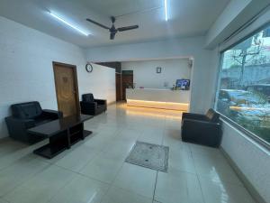 德瓦纳哈利-班加罗尔JN Guestline的客厅配有两把椅子、一张桌子和一扇窗户