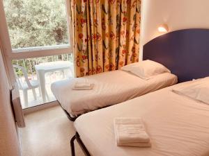 圣特罗让莱班Arc en Ciel Oléron的酒店客房设有两张床和窗户。