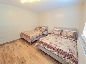 East BarnetLondon Luxury 2 Bedroom Flat Sleeps 8 free parking的一间卧室设有两张床,铺有木地板