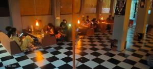 亨比Taste Of Hampi - Stay @ Nature的一群人坐在一个有格子地板的房间