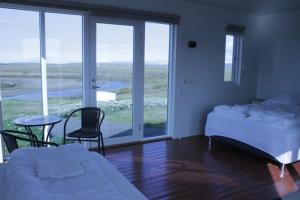 VíðirhóllGrímstunga Guesthouse的卧室配有一张床和一张桌子及椅子