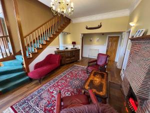 廷瓦尔亨利斯雷别墅酒店的一间带红色椅子和楼梯的客厅