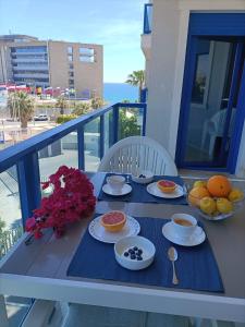 阿利坎特Alicante Mar的阳台上摆放着食物盘的桌子