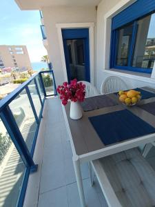 阿利坎特Alicante Mar的阳台上的桌子上放着花瓶和水果