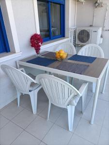 阿利坎特Alicante Mar的一张白色的桌子和椅子,上面放着一碗水果
