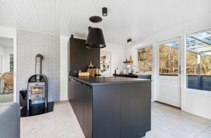 维斯特索马肯Lovely Summer House With Bornholm Atmosphere,的厨房配有黑色柜台和炉灶。