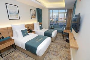 吉达ِAluya Hotel的酒店客房设有两张床和电视。