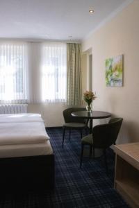 布尔格Hotel Bleske im Spreewald的酒店客房带一张床、一张桌子和椅子