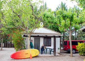 卡斯佩TAIGA Lake Caspe的两人坐在房子前面,房子里有两个冲浪板