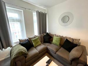 BiglisSpacious two bedroom flat in Barry的客厅配有棕色的沙发和镜子