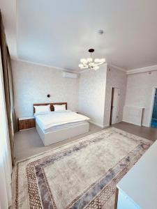 卡拉甘达Hotel Bereket Karaganda的卧室配有白色的床和地毯。