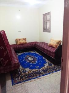 Inezganehotel appart inezgane agadir的带沙发和蓝色地毯的客厅