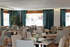 德尼亚Hotel MR Costa Blanca的用餐室设有桌椅和窗户。
