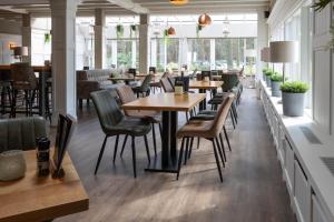 宁斯佩特Boslodges Veluwe的餐厅设有木桌、椅子和窗户。