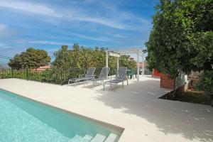 阿尔豪林德拉托里TESS Villa Paz的一个带椅子的庭院和一个游泳池