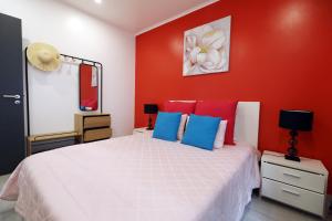 MaiaCasa da Calheta的卧室配有白色的床铺和红色的墙壁