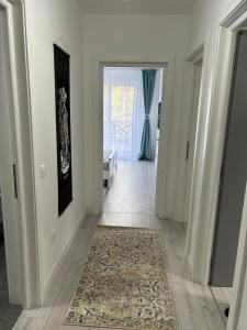 普洛耶什蒂White DeLuxe Apartment的地板上铺着地毯的白色走廊