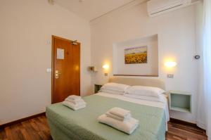 基安奇安诺泰尔梅Hotel Del Buono Wellness & Medical Spa的一间卧室配有一张床,上面有两条毛巾