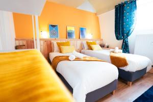 蒙斯Lets Relax - Coté Soleil Levant的配有两张床铺的黄色墙壁和蓝色窗帘
