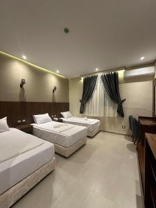开罗Sama hotel的酒店客房配有两张床和一张书桌