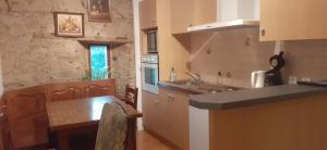 安克特维尔Manoir de la Foulerie的厨房配有柜台和桌子