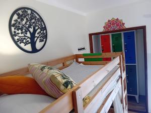 纳扎雷Paz & Amor Guest House - Peace & Love的一间卧室配有一张双层床和墙上的时钟