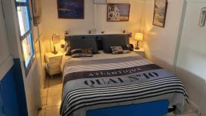 奥雷龙圣皮耶尔La cabane Oléronnaise的一间卧室配有一张带黑白毯子的床