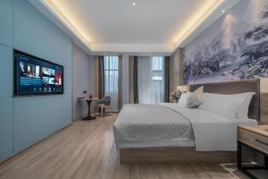 鄱阳莫林酒店鄱阳体育中心店的一间卧室配有一张大床和一台平面电视