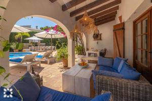 莫莱拉Villa Cogoll by Abahana Villas的户外庭院配有蓝色的沙发和遮阳伞。