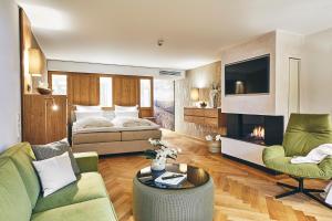 施马伦贝格戴曼酒店的客厅配有床、沙发和电视。