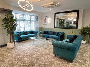 布莱克浦罗斯金酒店的客厅配有蓝色的沙发和镜子